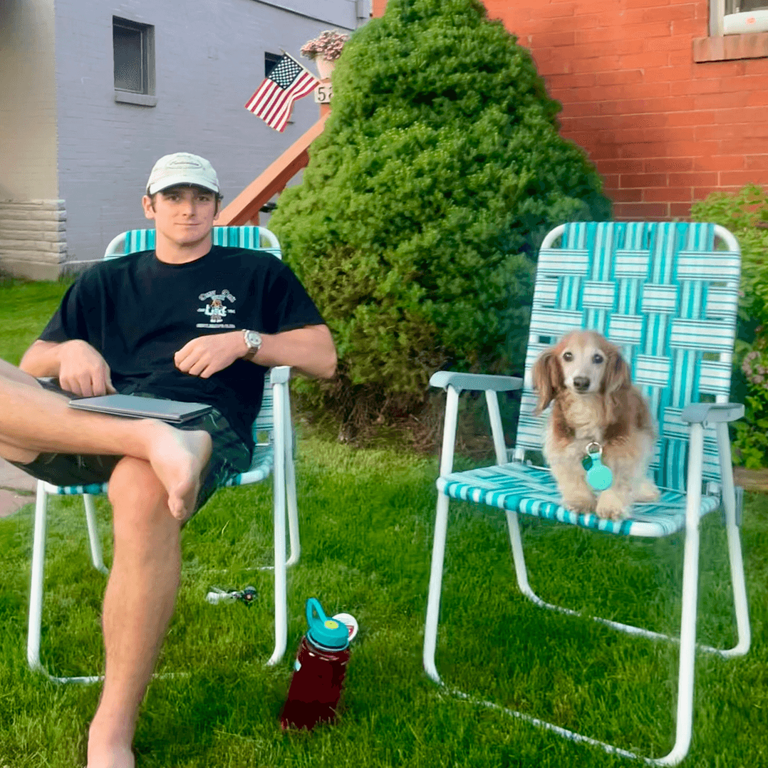 Charlie sitting outdoors beside a dog